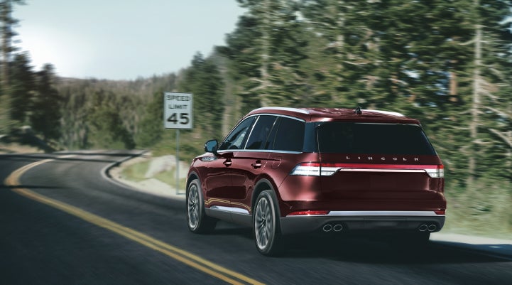 A 2024 Lincoln Aviator® SUV is being driven on a winding mountain road | Maguire's Lincoln in Palmyra PA