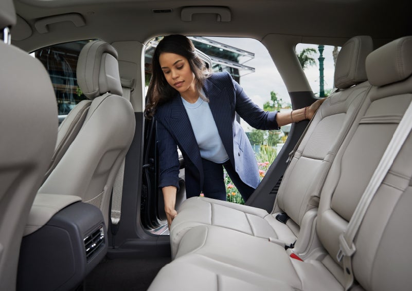 A woman slides the second-row seat forward to create more cargo space | Maguire's Lincoln in Palmyra PA